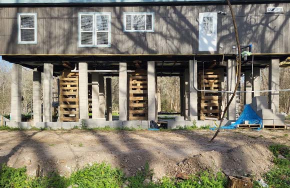 A home that has been lifted on a pier and beam foundation to protect it from flood waters.